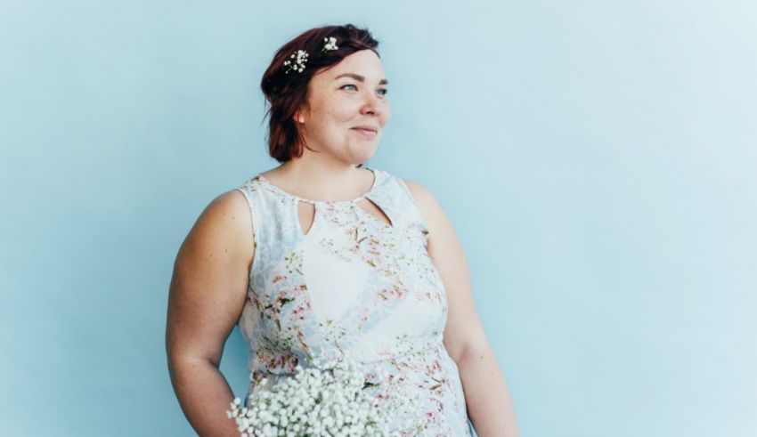 A woman in a floral dress holding a bouquet of baby's breath.