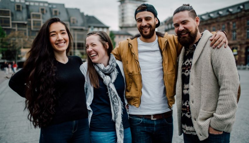 Four young people posing for a photo in front of a building.