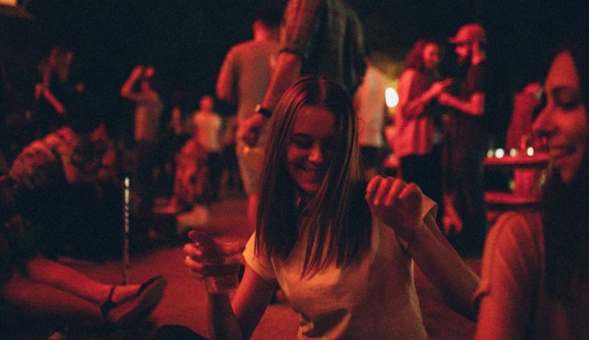 A woman sitting on the ground with her hands up.