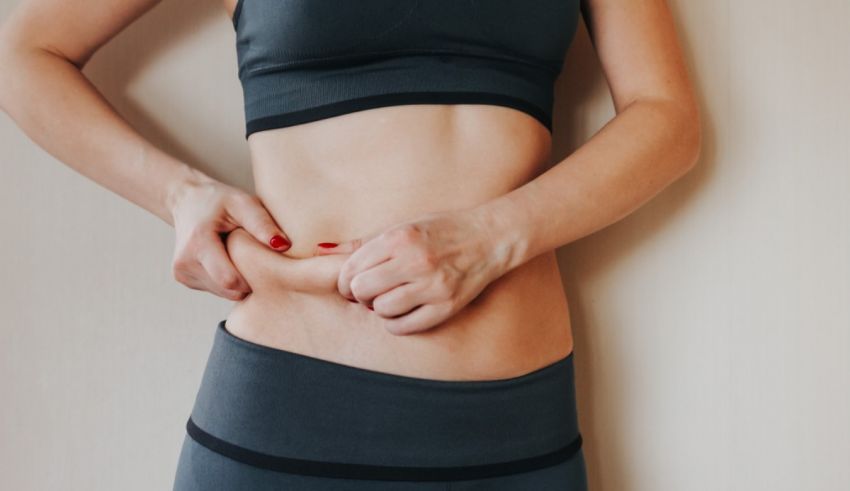 A woman is putting her hand on her stomach.