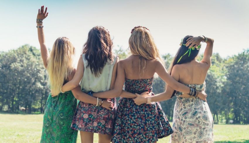 A group of girls standing in a field with their arms raised.