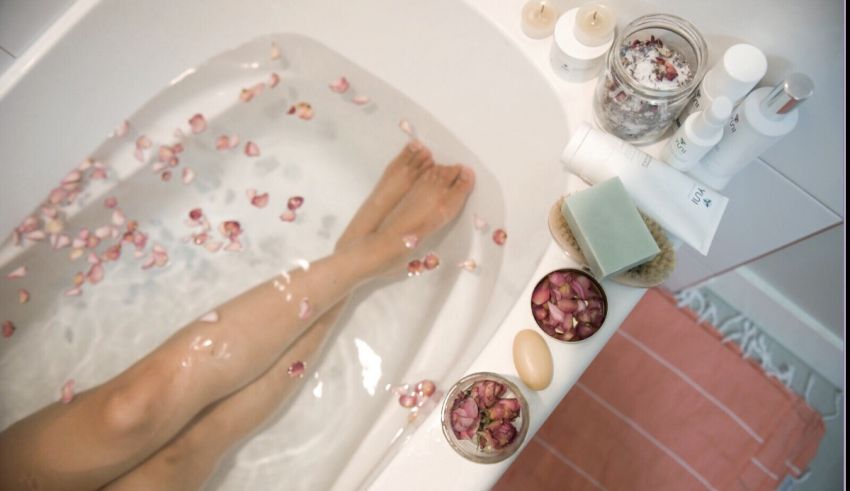 A woman's feet in a bath tub filled with rose petals.