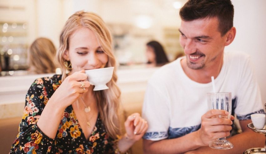 A man and woman drinking from a cup.