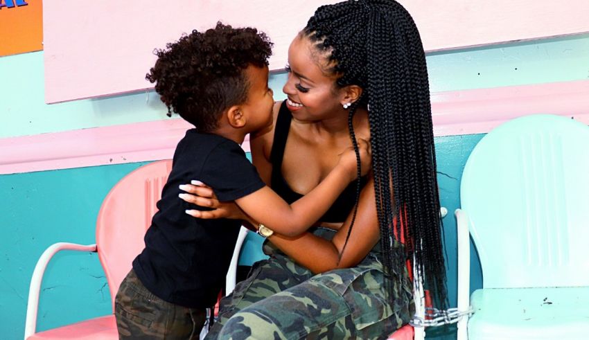 A woman is hugging her son in a classroom.