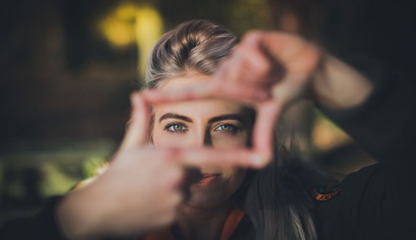 A woman holding up a frame with her hands.