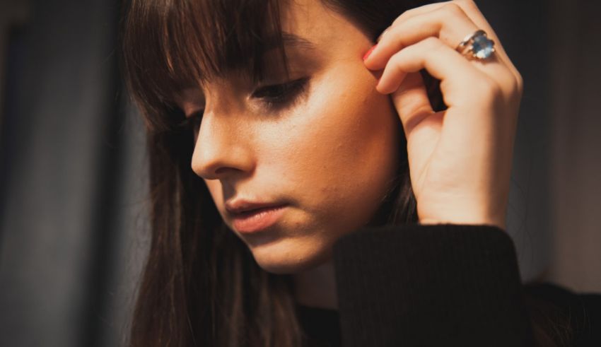 A woman wearing a black sweater with a ring on her finger.