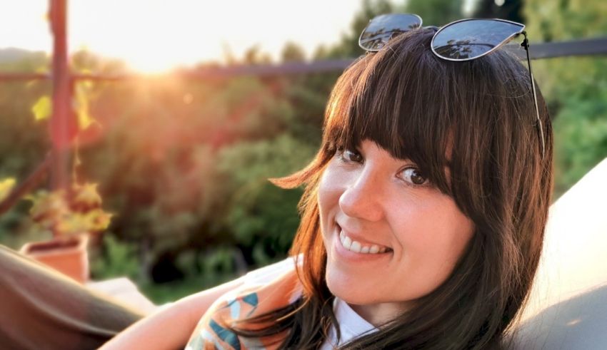 A woman smiling with sunglasses on her head.