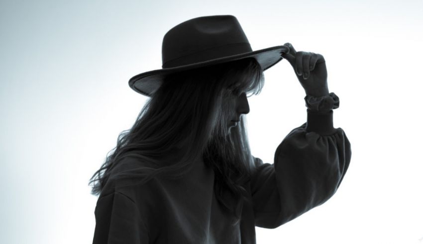 A silhouette of a woman wearing a hat.