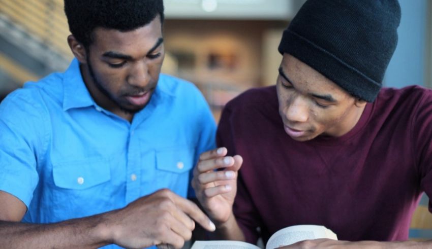 A couple of men looking at a book.