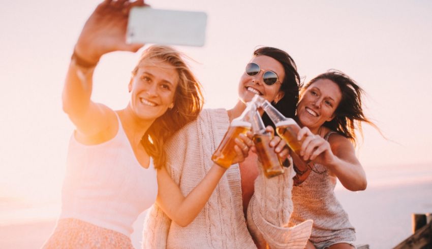 A group of women holding bottles of beer.
