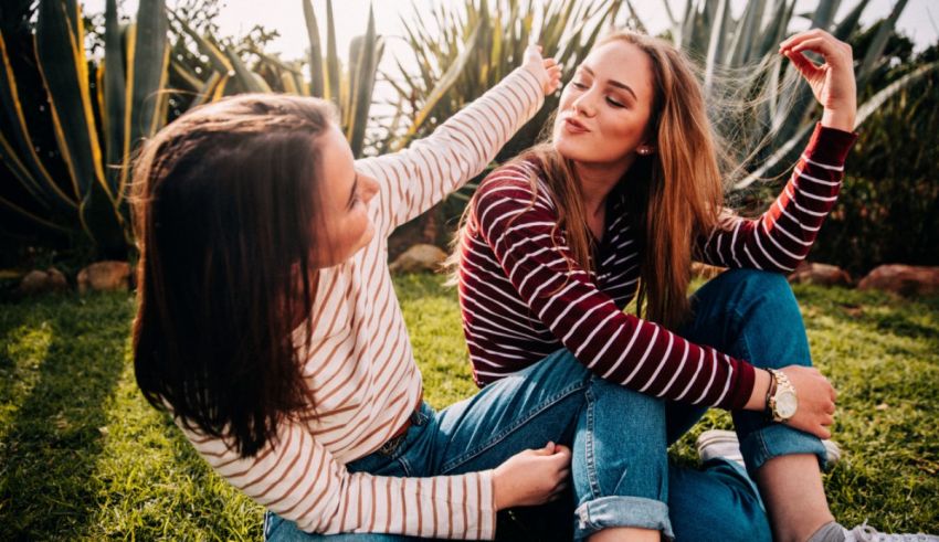 Two women sitting on grass.
