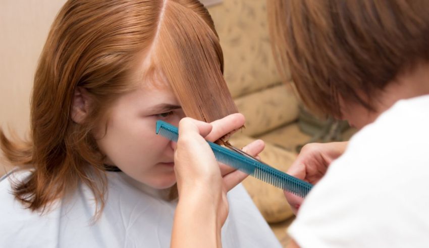 A woman is getting her hair cut by a hairdresser.