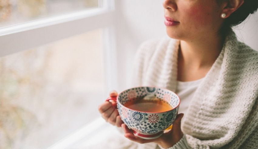 A woman holding a cup of tea.
