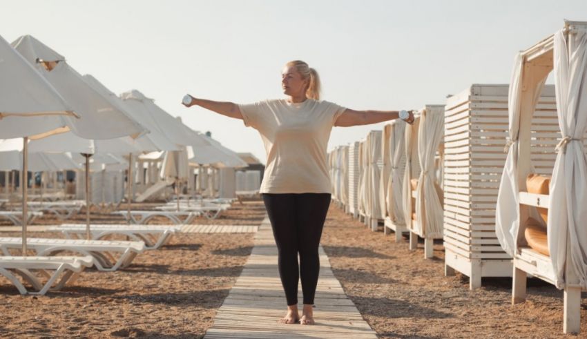 A woman is standing on a beach with white umbrellas.