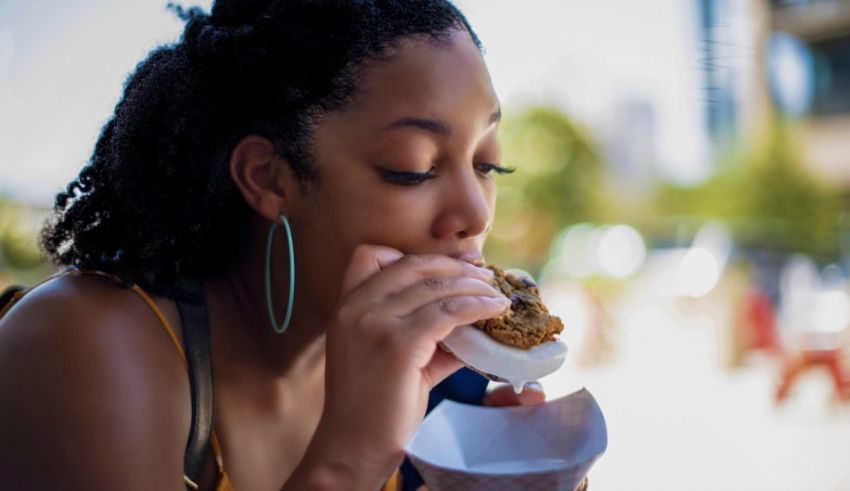 A woman eating a donut while sitting outside.