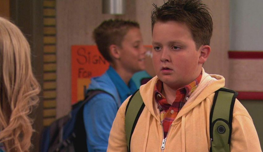 A young boy in a yellow jacket standing next to other people.