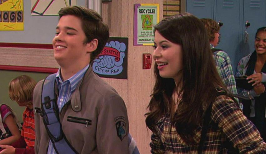 A boy and a girl standing in a school hallway.