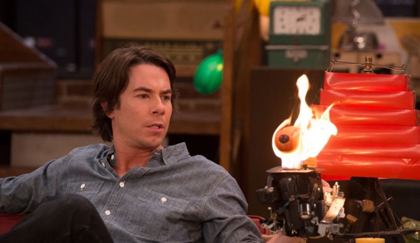 A man sitting on a couch with a fire in his hands.