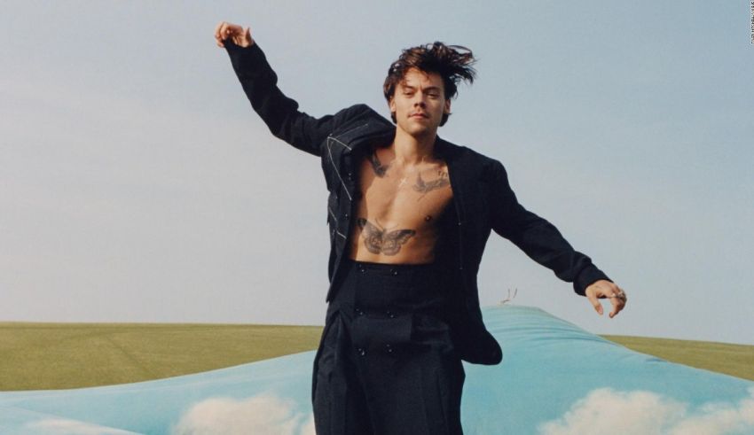 A man with tattoos standing on top of a cloud.