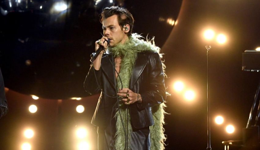 A man in a green jacket singing into a microphone.