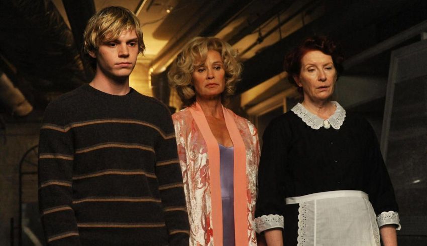 Three people standing next to each other in a hallway.