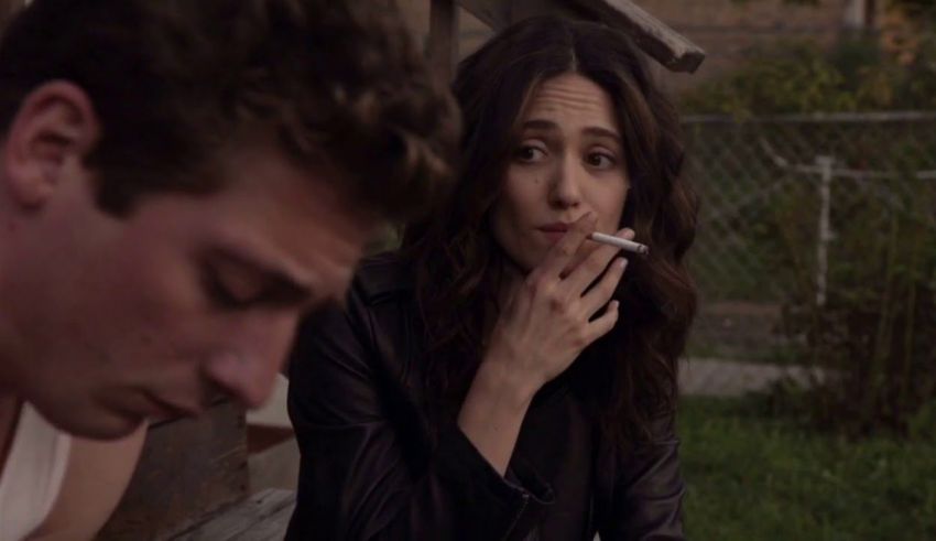 A woman smoking a cigarette next to a man.