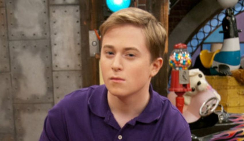 A young man in a purple shirt sitting on a couch.