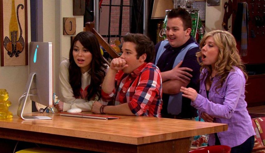 A group of people sitting around a table in front of a computer.