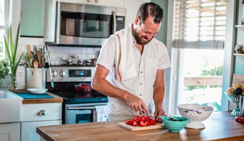 A man in a white shirt is preparing food in a kitchen.