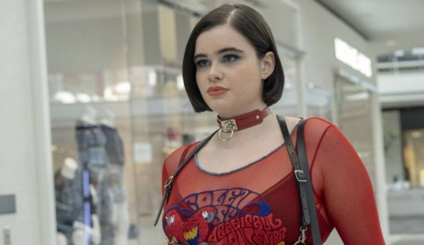 A woman in a red dress is standing in a mall.