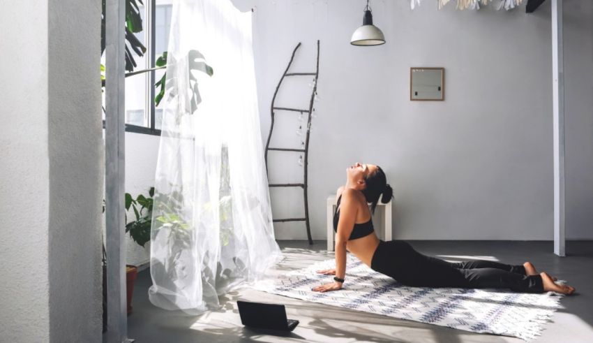 A woman doing yoga in a room with plants.