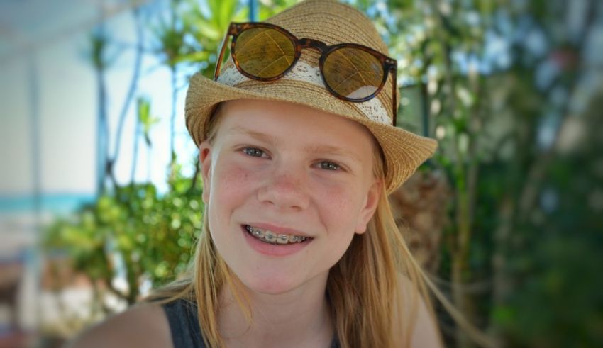 A girl wearing sunglasses and a straw hat.