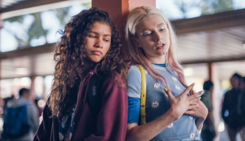 Two girls standing next to each other in a school hallway.