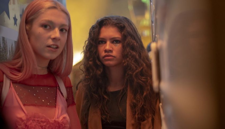 Two young women standing next to each other in a hallway.
