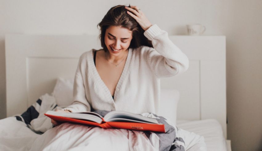 A woman reading a book in bed.