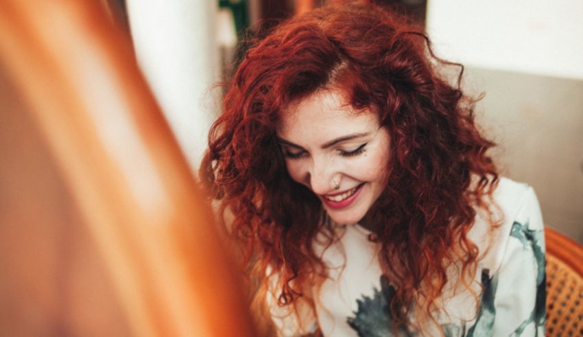 A woman with red hair sitting at a table.