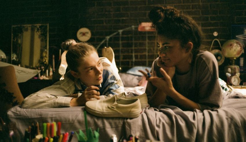 Two girls laying on a bed in a room.