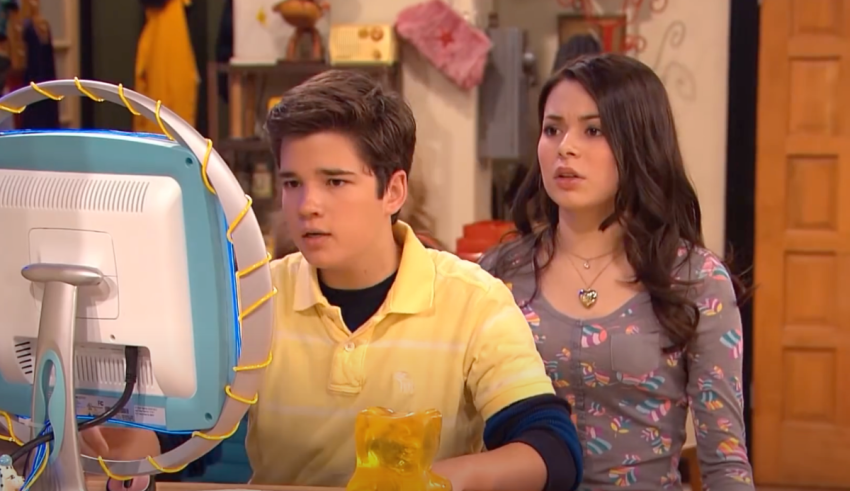 A boy and girl sitting in front of a computer.