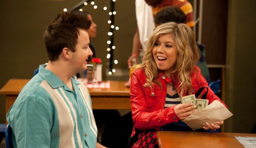A man and a woman sitting at a table with money.
