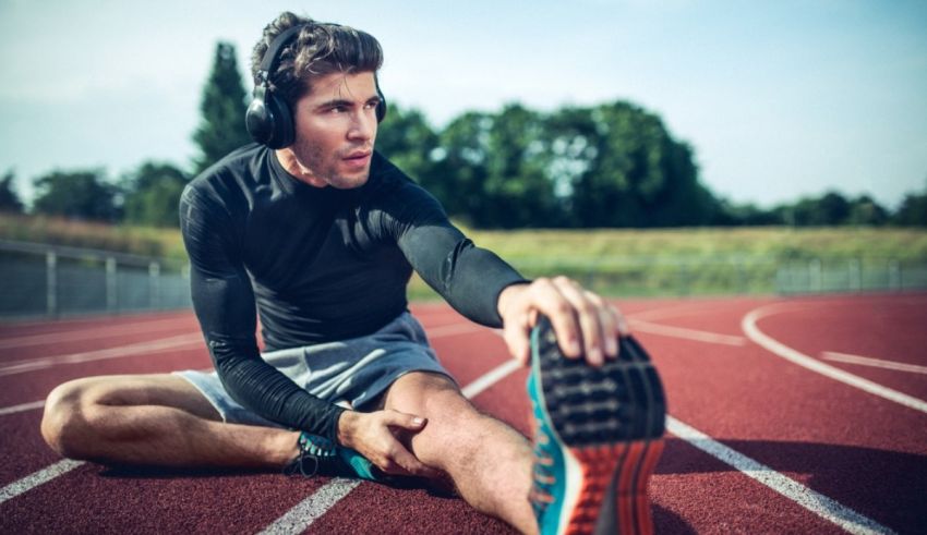 A man stretching his leg on a running track.