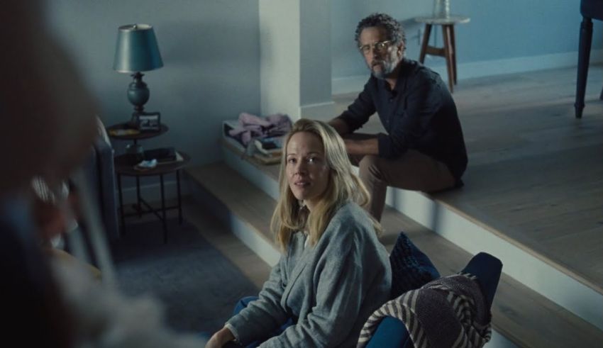 A man and woman sitting on the floor in a living room.