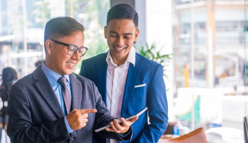 Two businessmen looking at a tablet in an office.