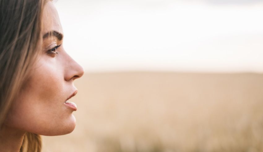 A woman looking out into a wheat field.