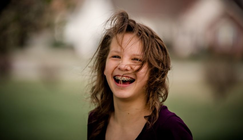 A young girl laughing in front of a house.