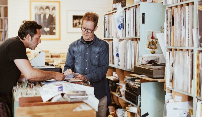 Two men in a record store looking at records.