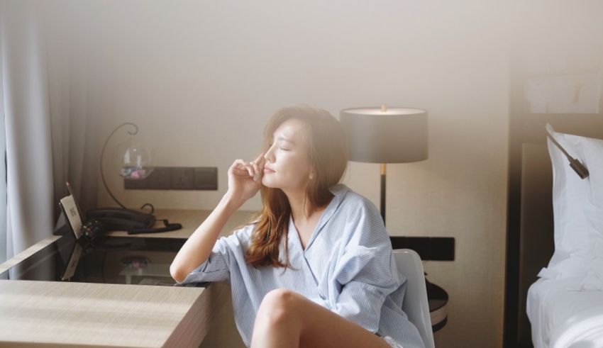 A woman sitting on a bed in a hotel room.