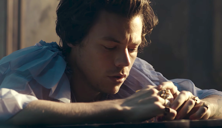 A man is laying on a table with his hands in his pockets.