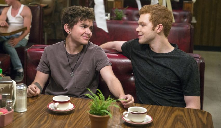 Two young men sitting at a table in a diner.