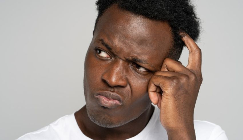 A black man with his hand on his head.