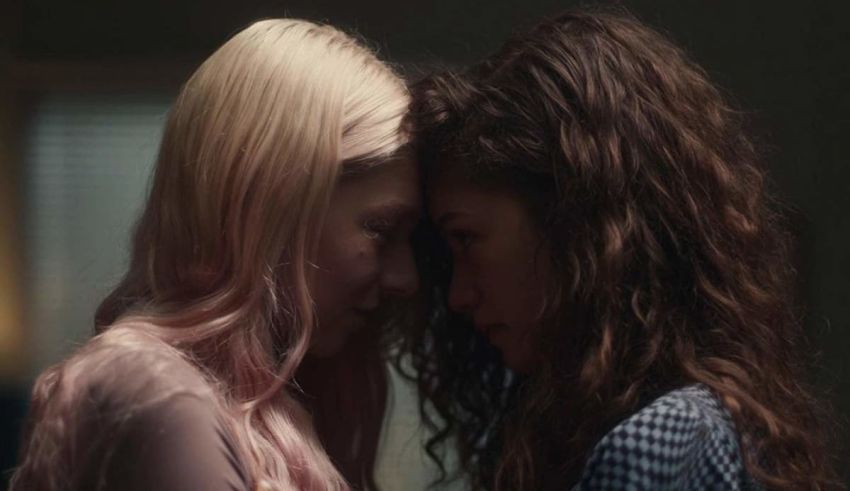 Two young women looking at each other in a dark room.